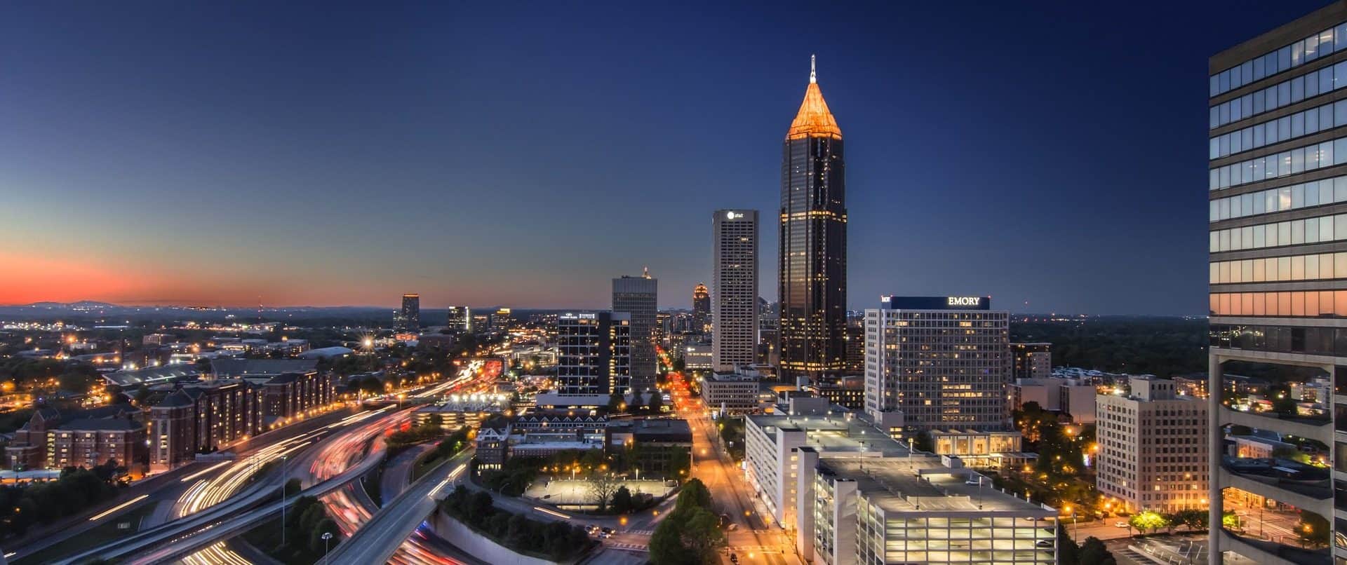 Midtown Atlanta at dusk with traffic along the Downtown Connector