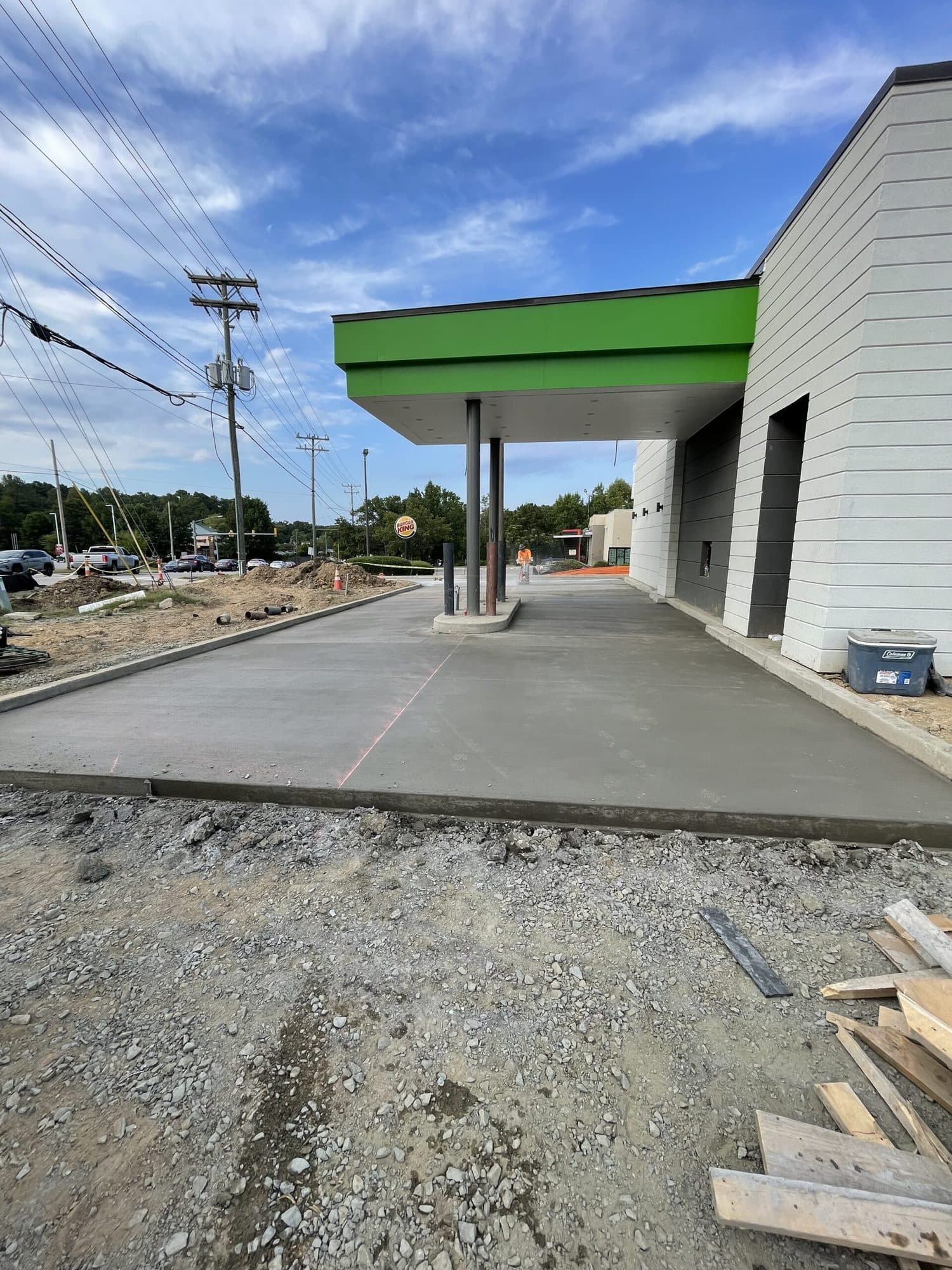 Freshly poured concrete drive-through lane running under a restaurant canopy
