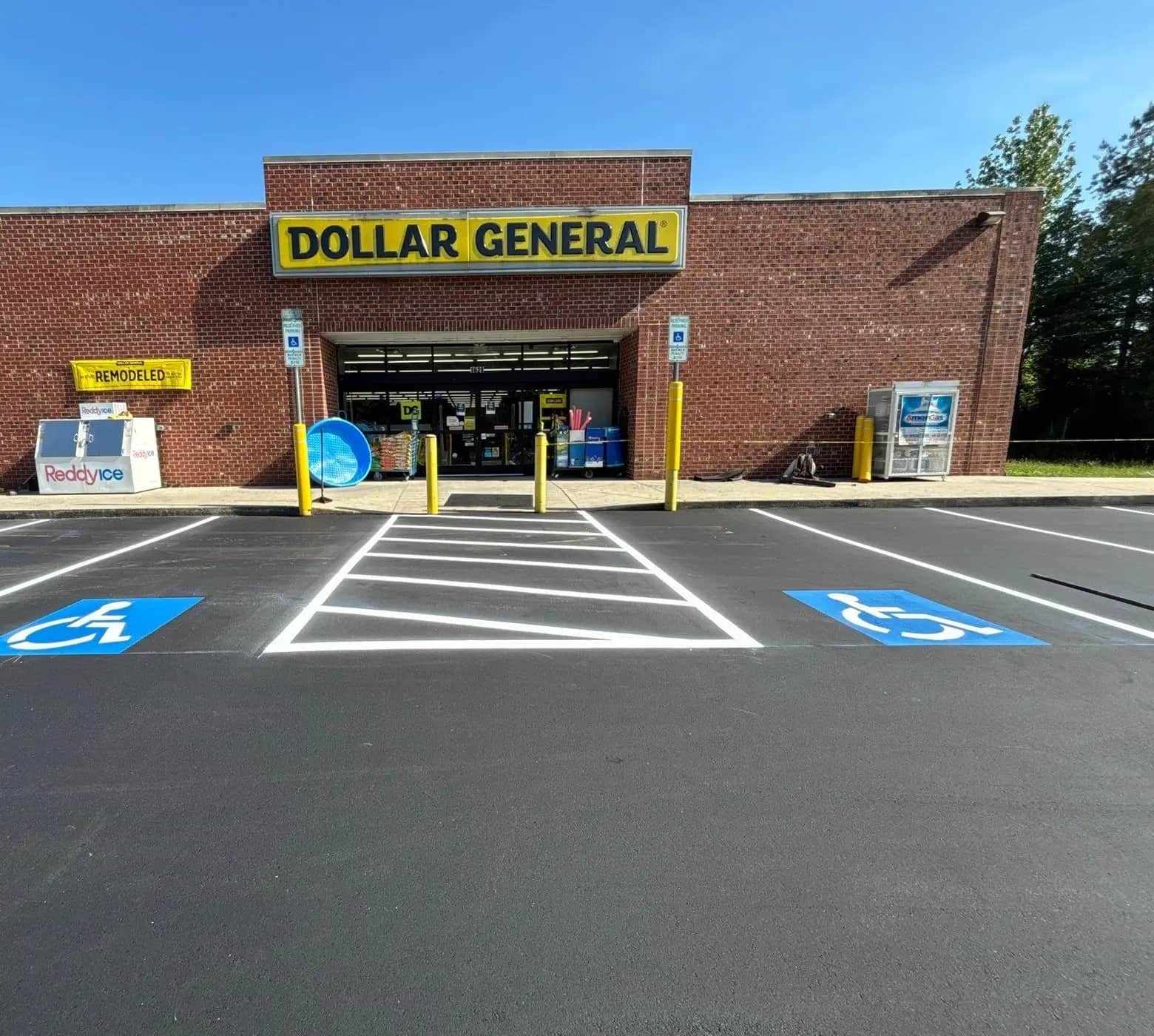 Yellow bollards and accessible parking signage at a Dollar General storefront in Monroe NC