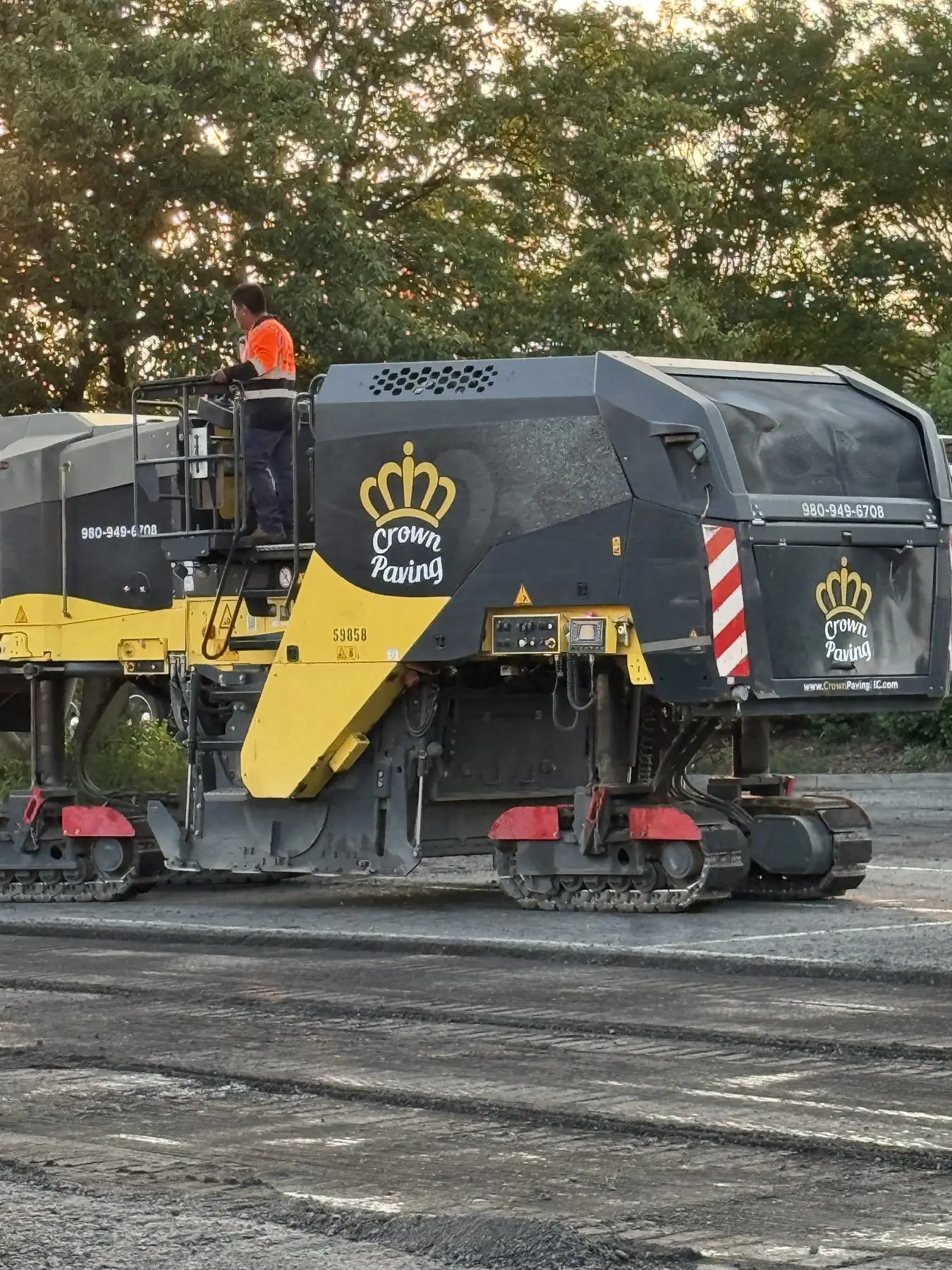 A Crown Paving milling machine part-way through cutting out a striped commercial lot