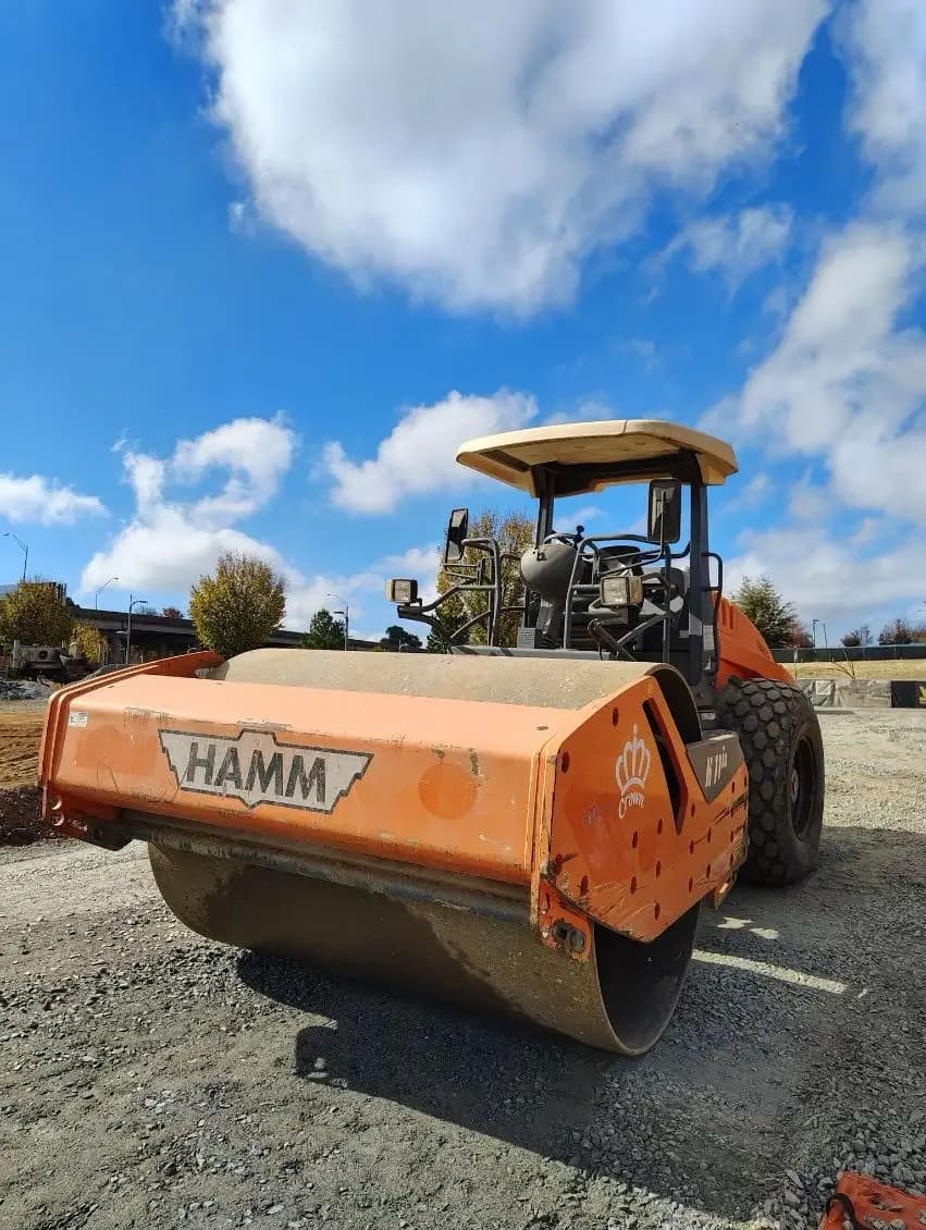 Compaction roller finishing a new roadway surface