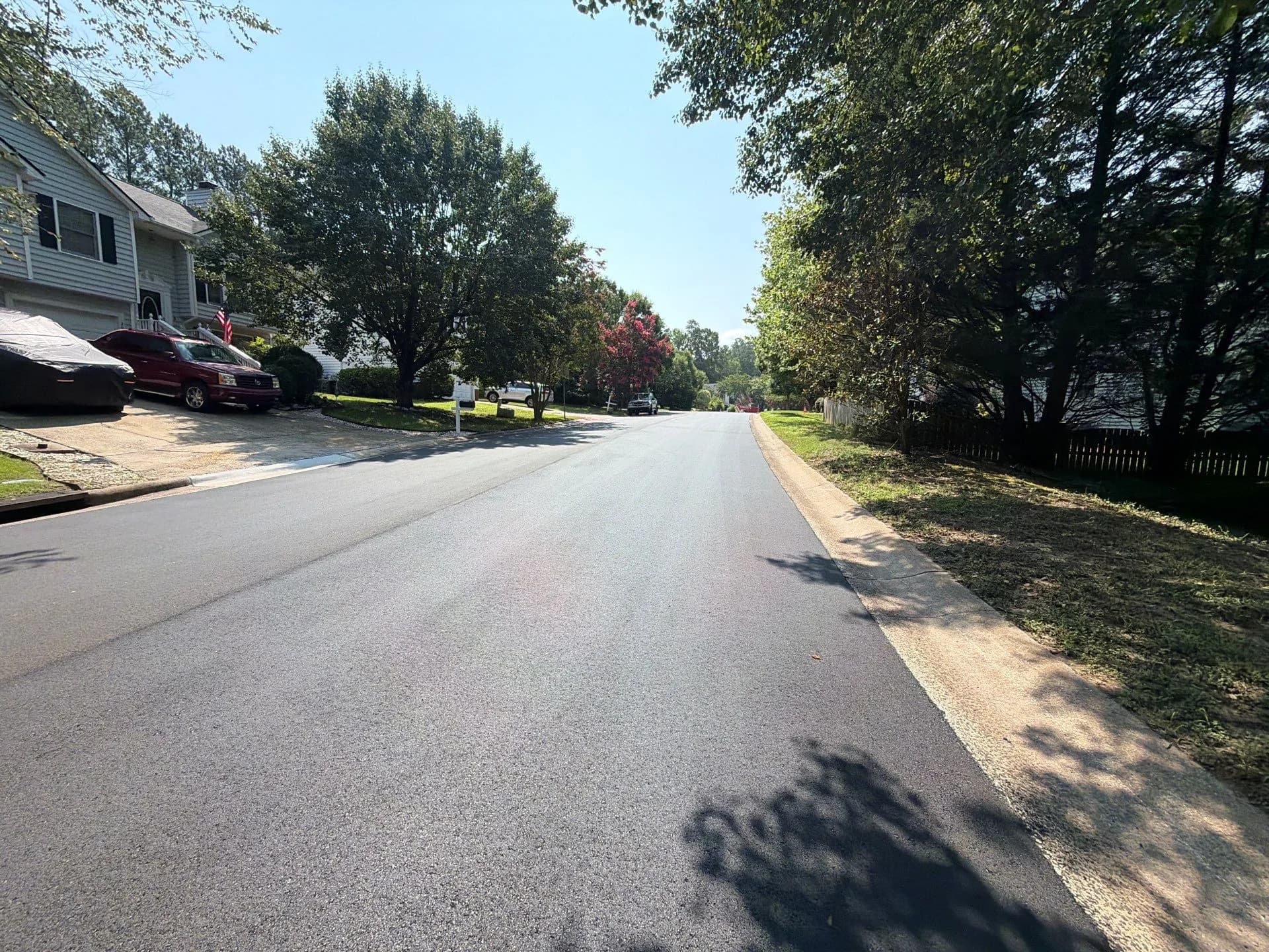Resurfaced drive running past homes and mature trees
