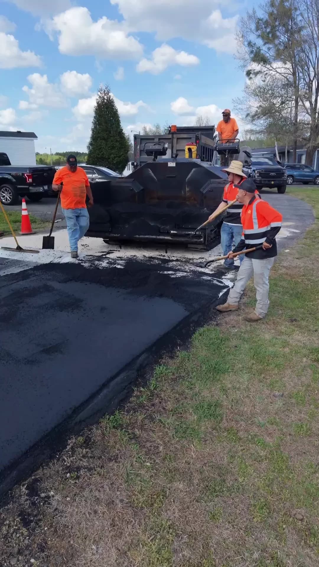 Crown Paving paver and crew laying a roadway through a manufactured home community
