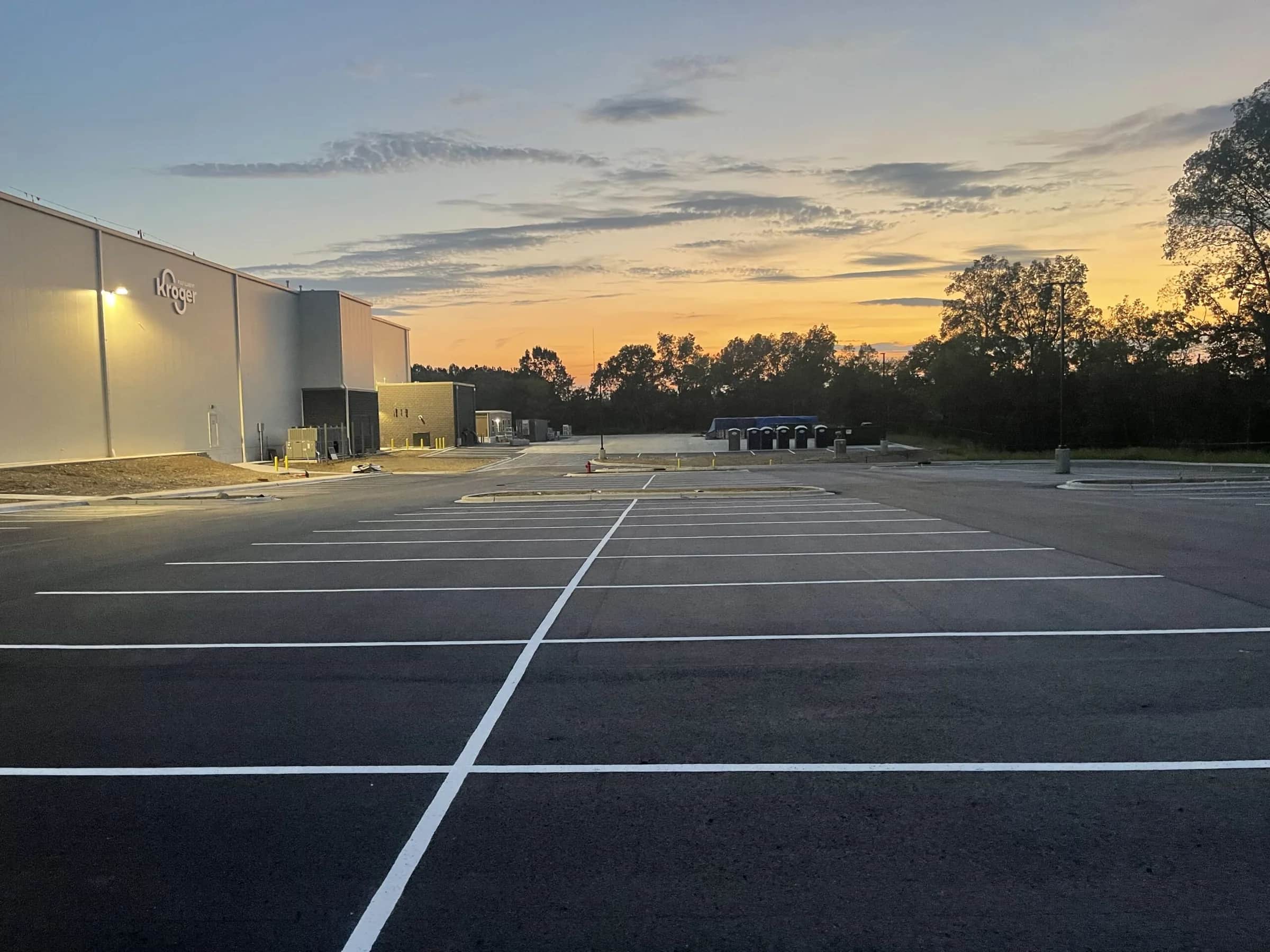 Freshly paved and striped lot at a Kroger fulfillment centre at dusk