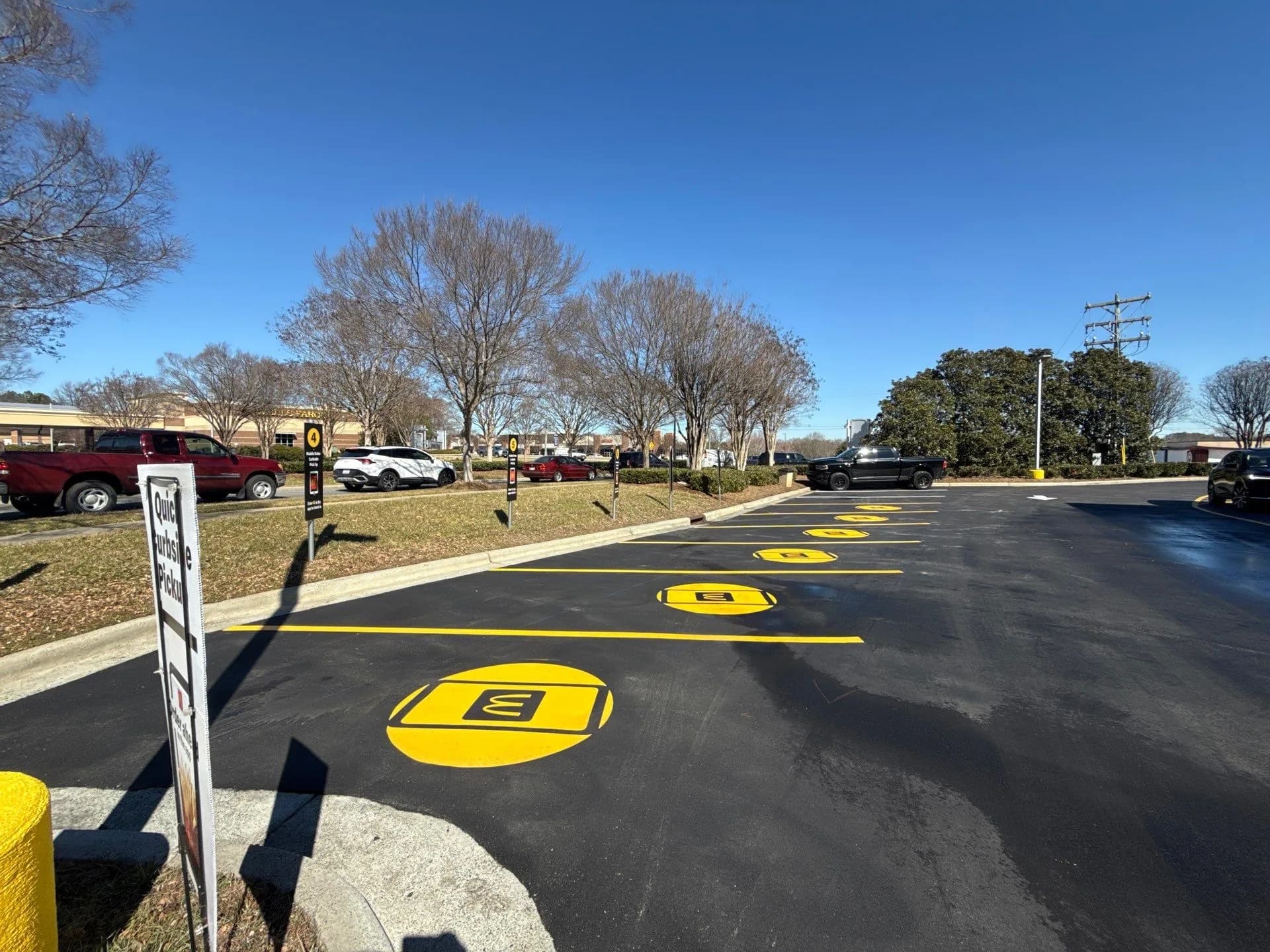 Numbered curbside pickup stalls marked with McDonald's roundel stencils and fresh yellow striping
