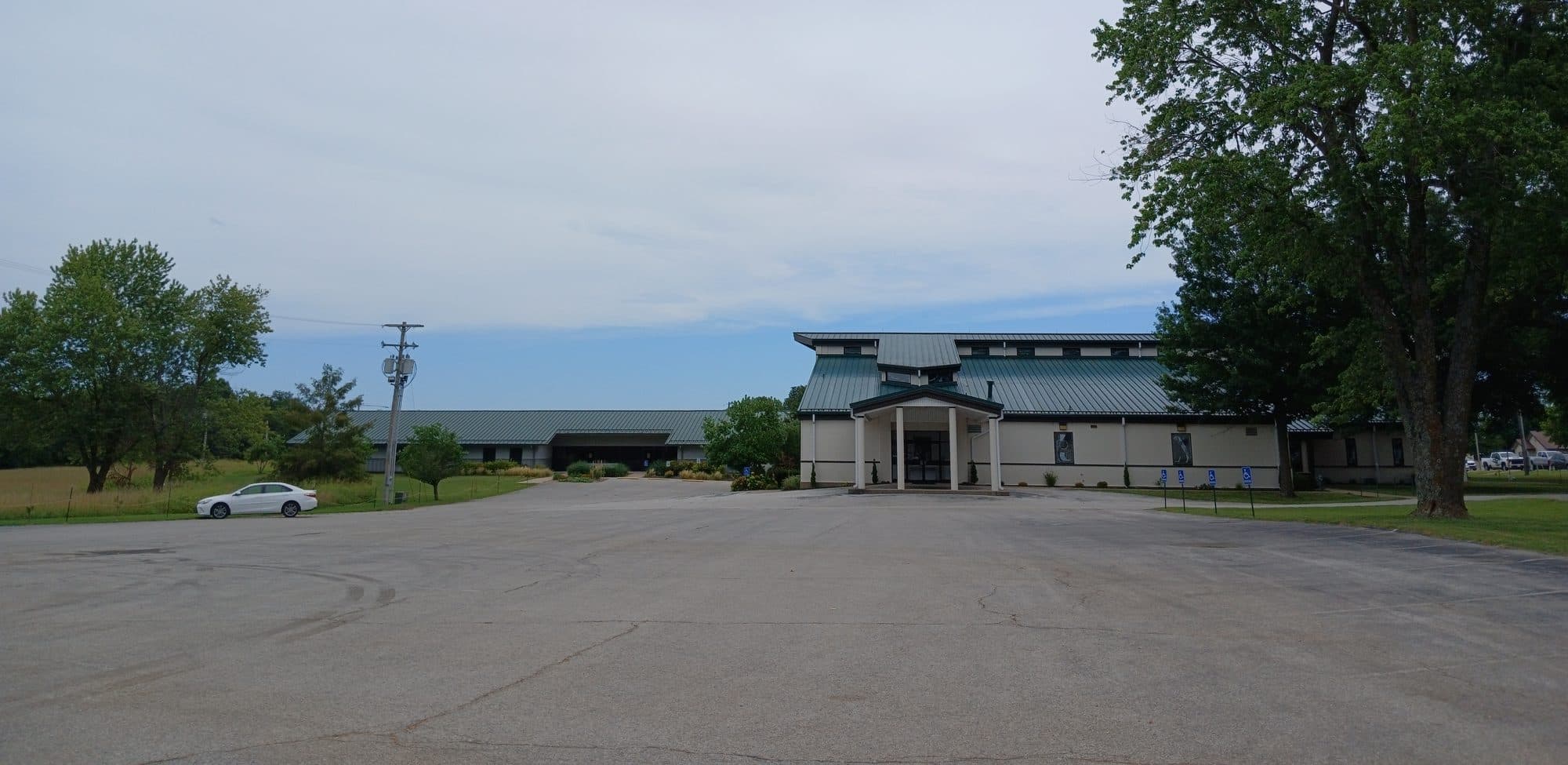 A church building seen across its empty asphalt parking lot