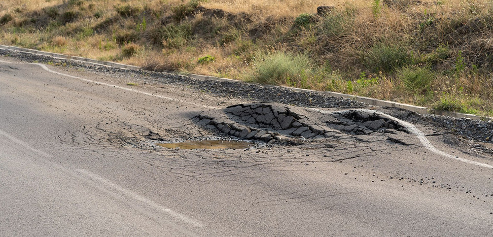 Pot hole in a non-compliant parking lot
